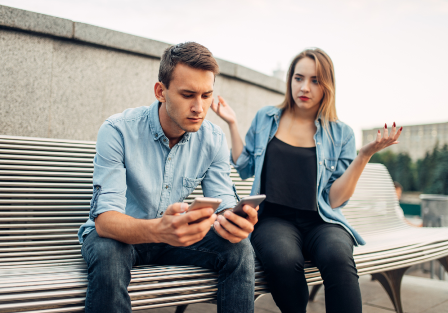 mężczyzna siedzi na telefonie i tym samym ignoruje żonę